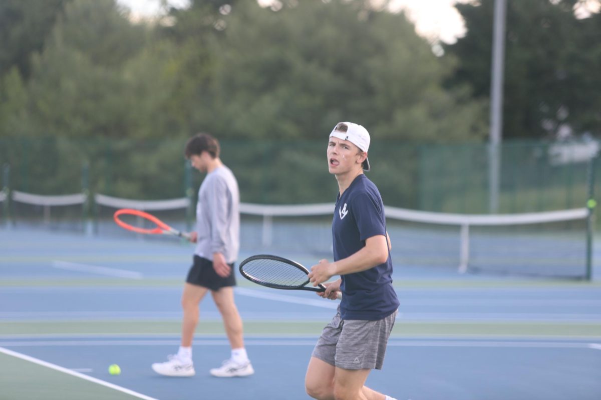 Senior Louis Gibson walking back to his spot so he can serve the ball.