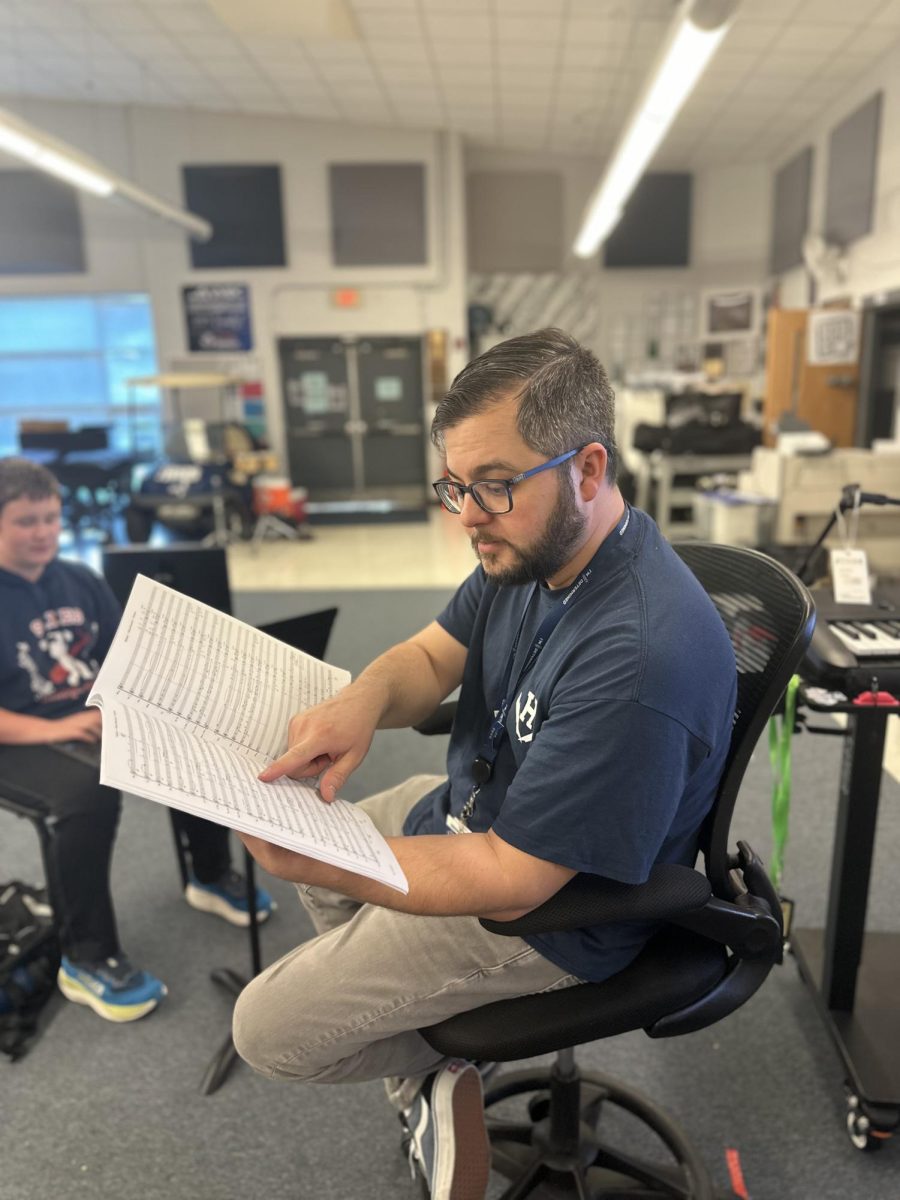 Daniel upton showing his student what needs to me written.