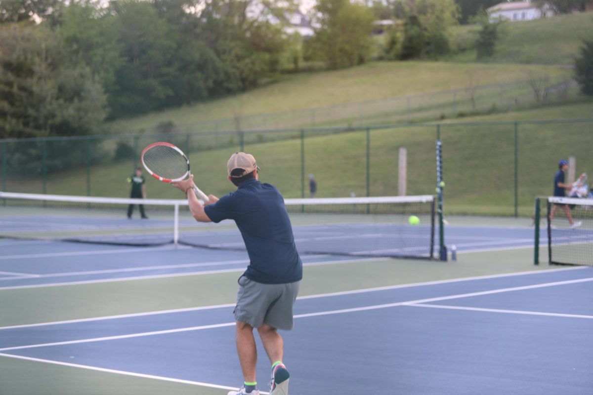 Senior Gabe Sabarre hitting the tennis ball.