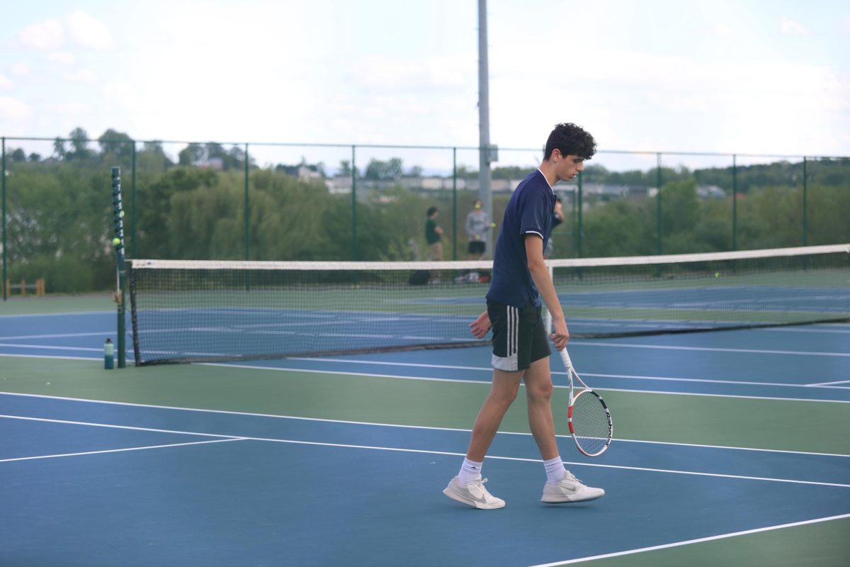 Junior Tristan Nussbaum walking to his spot to serve the ball.