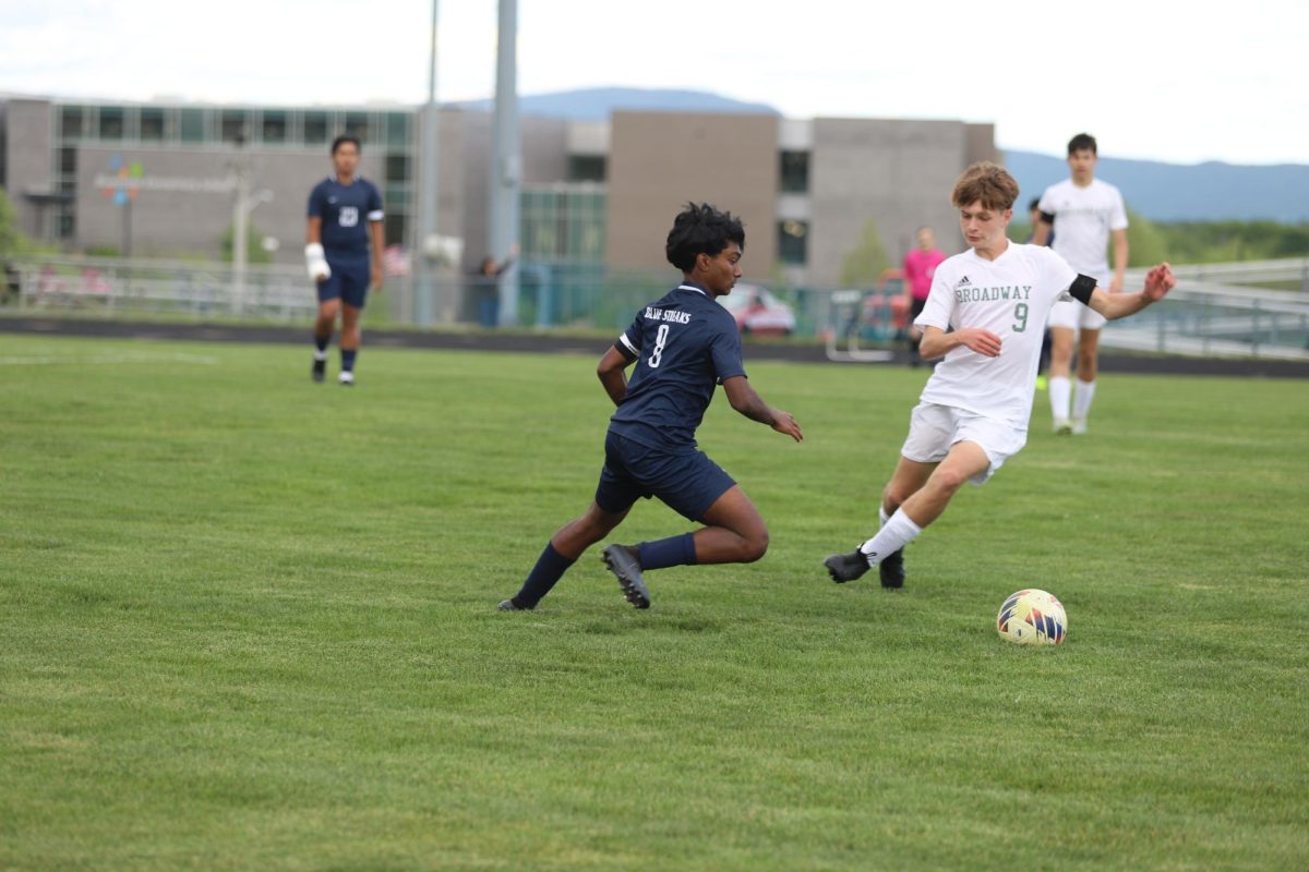 Sophomore Kaiden Velasquez kicking the ball away from his opponent. 