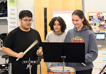 Frankie Ruiz, Eliza Malcolm, and Elsie Corriston helping each other play.
