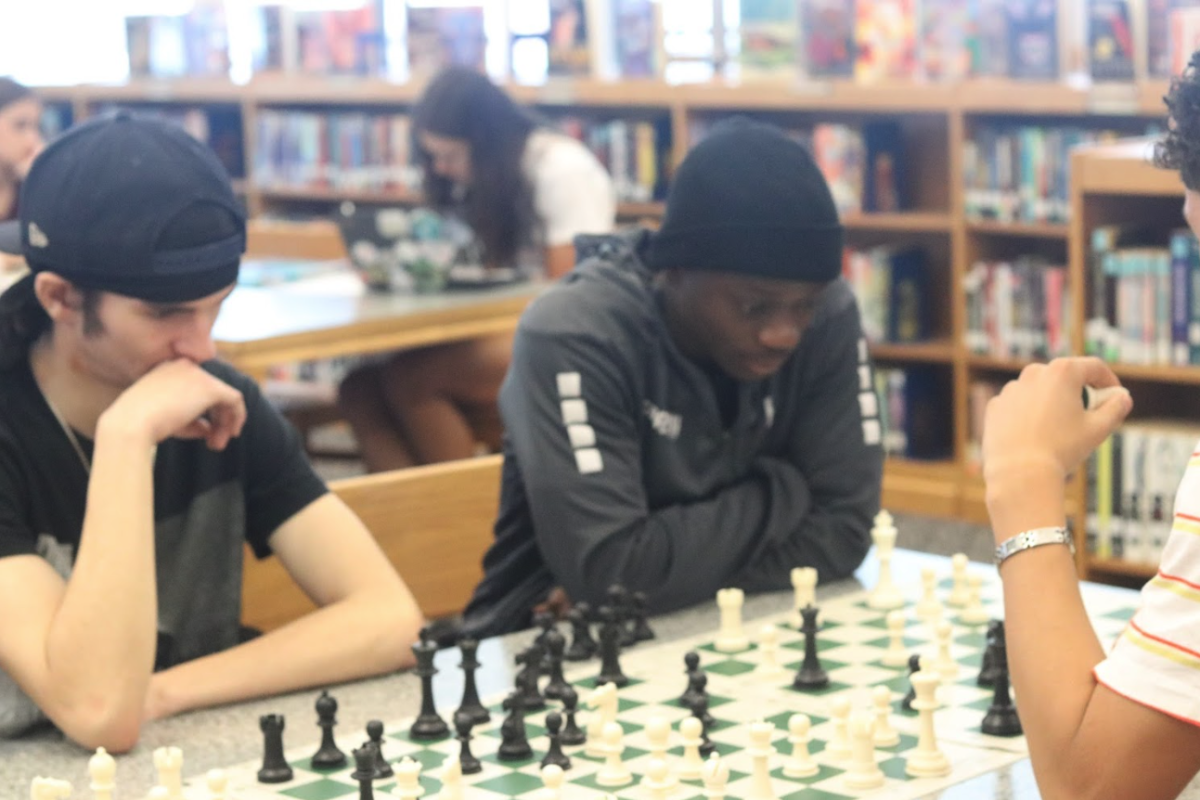 Students play a chess game.