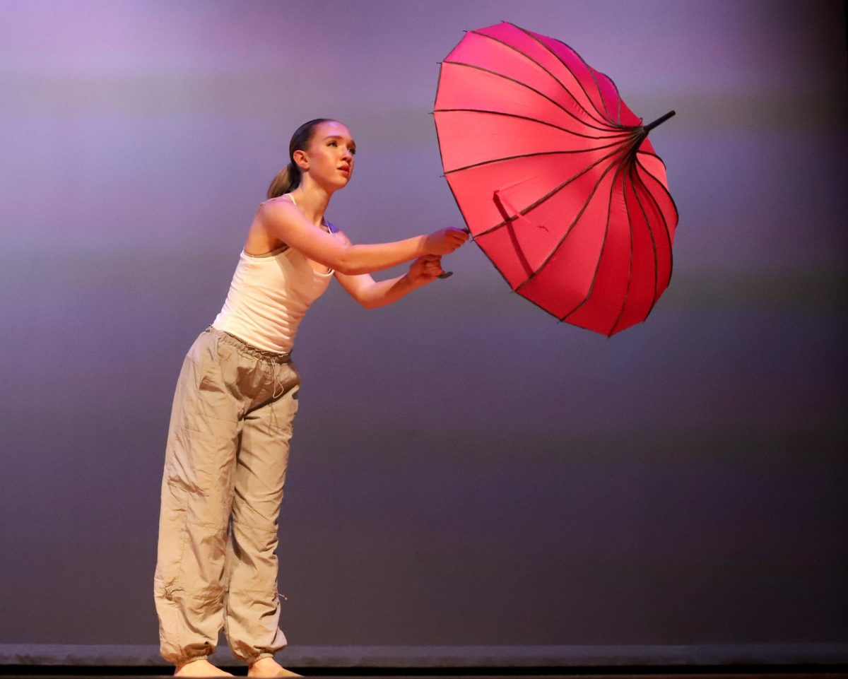Junior Abby Gibson dances with an umbrella in her honors piece.
