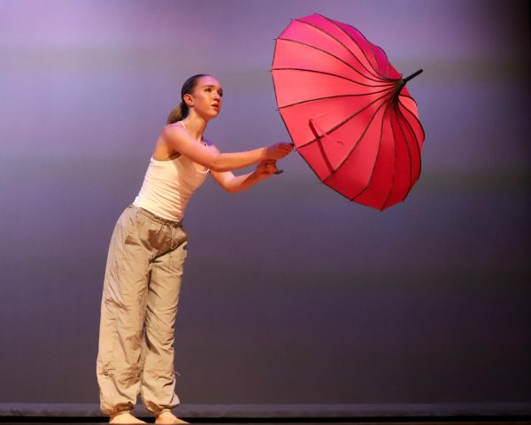 Junior Abby Gibson dances with an umbrella in her honors piece.