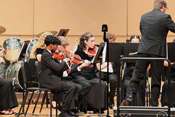 Up in the front the violinist are in perfect harmony.