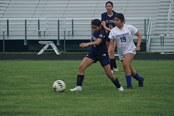 Player #6 is blocking the Spotswood player from stealing the ball.