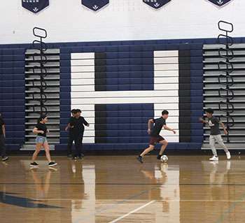 Students playing soccer as one of them, is about to score