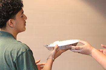 Junior Edwin Martinez is handed the pie.