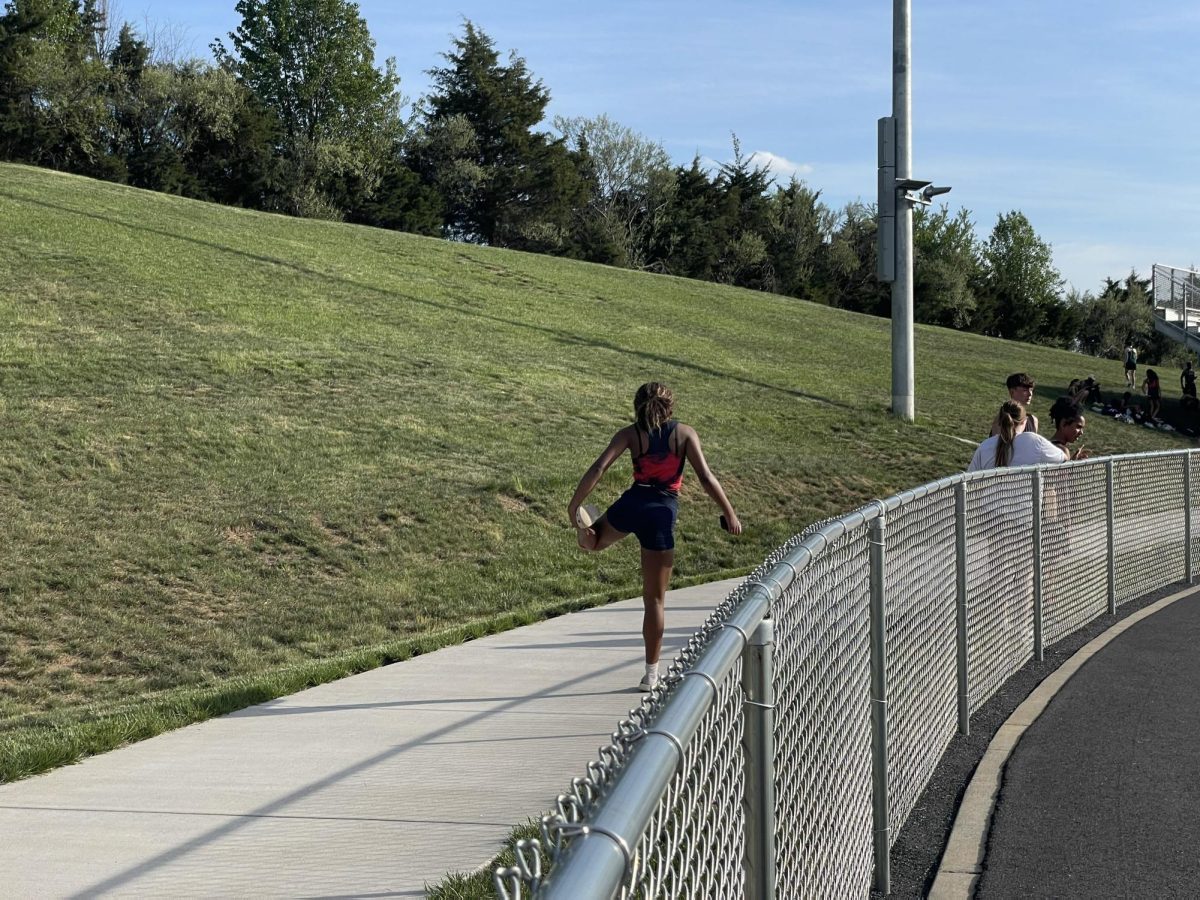Sophomore Kaylen De Los Santos Medina stretches before her event. 