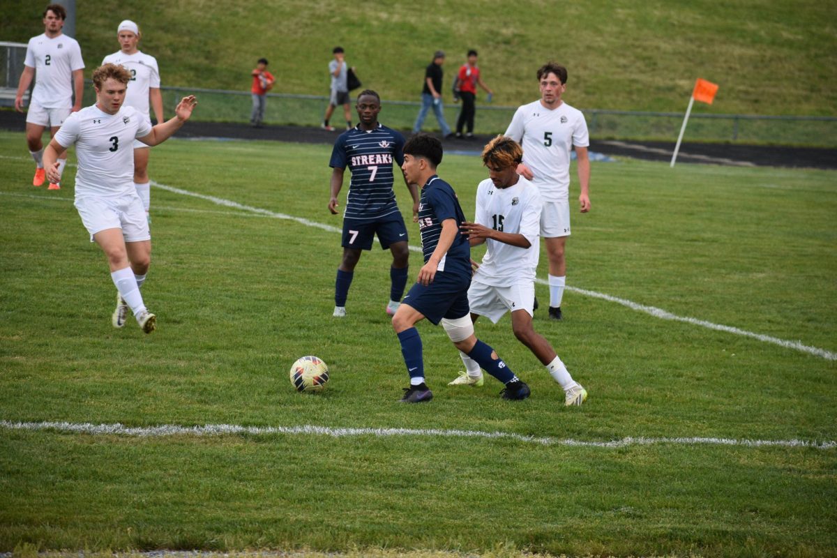 Sophomore Izaack Gonzalez dribbles the ball away from opponent.
