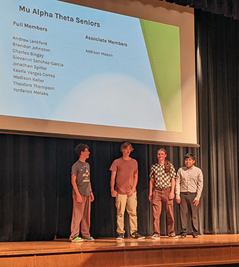 Some of the seniors of Mu Alpha Theta stand on stage.
