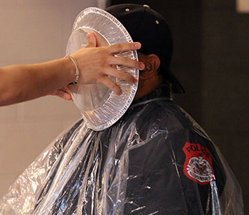 One of the staff members contributes to pieing Officer Terrell.