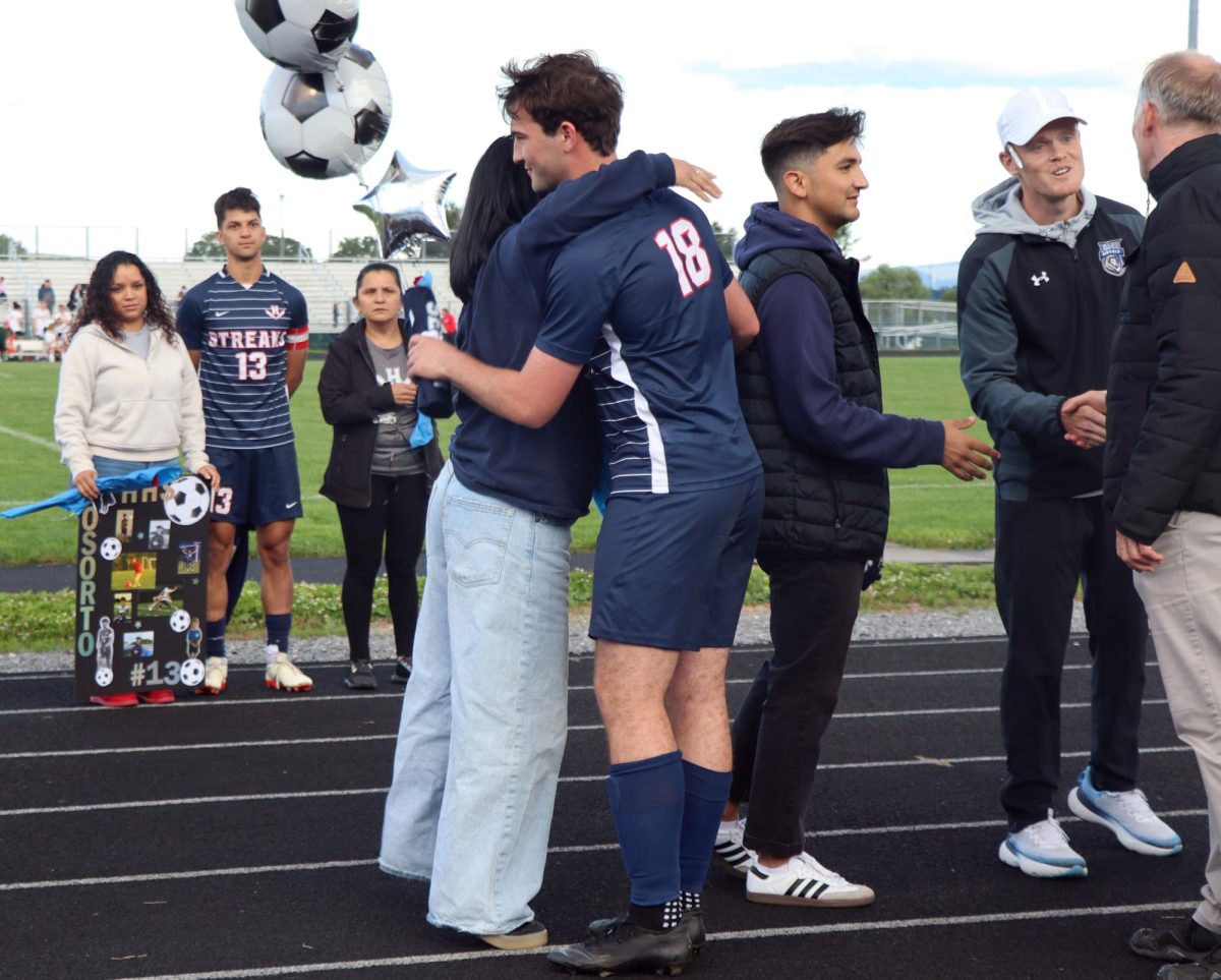Senior Arlo Von Rotz gives a hug at senior night.