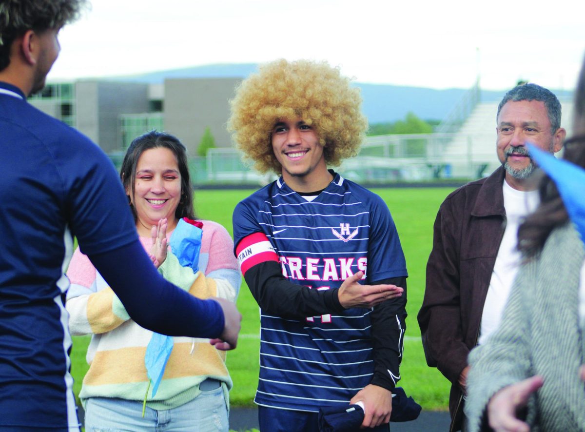 Senior Izaack Cruz Gonzalez is walked out by family members to celebrate senior night.