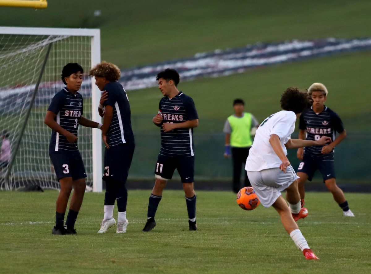 Boys soccer about to jumping up to block the ball.
