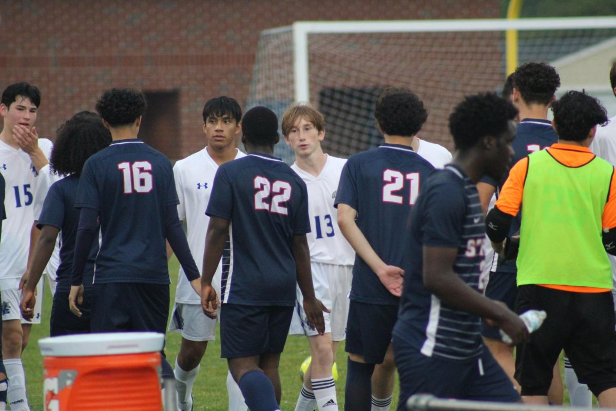 The boys Varsity soccer team showing great sportsmanship after the game.