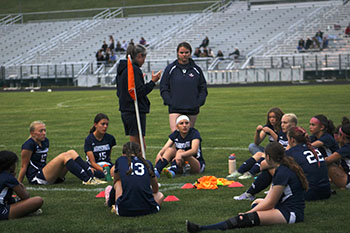 HHS varsity soccer girls having a group meeting after the game with broadway high school.