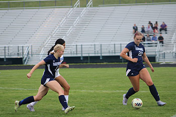 HHS varsity soccer player passing the ball to her teammate.