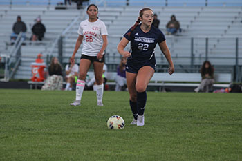 varsity soccer player #22 taking the lead with the ball.