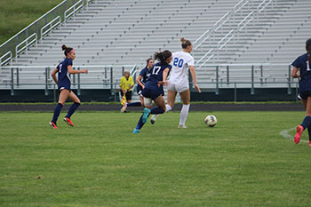 varsity girl soccer player #17 running towards the ball.
