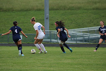 HHS varsity soccer players preparing to kick the soccer ball from the opponent.