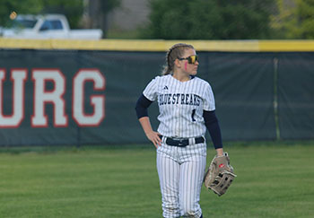 Varsity sophomore Addie Campbell in the left field looking at her teammates.