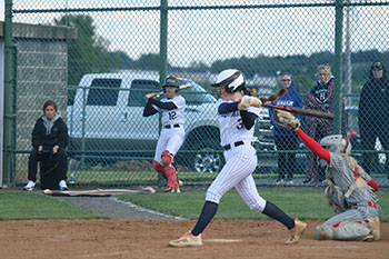 Varsity freshman softball player Delaney Dayton hits the ball with the bat.