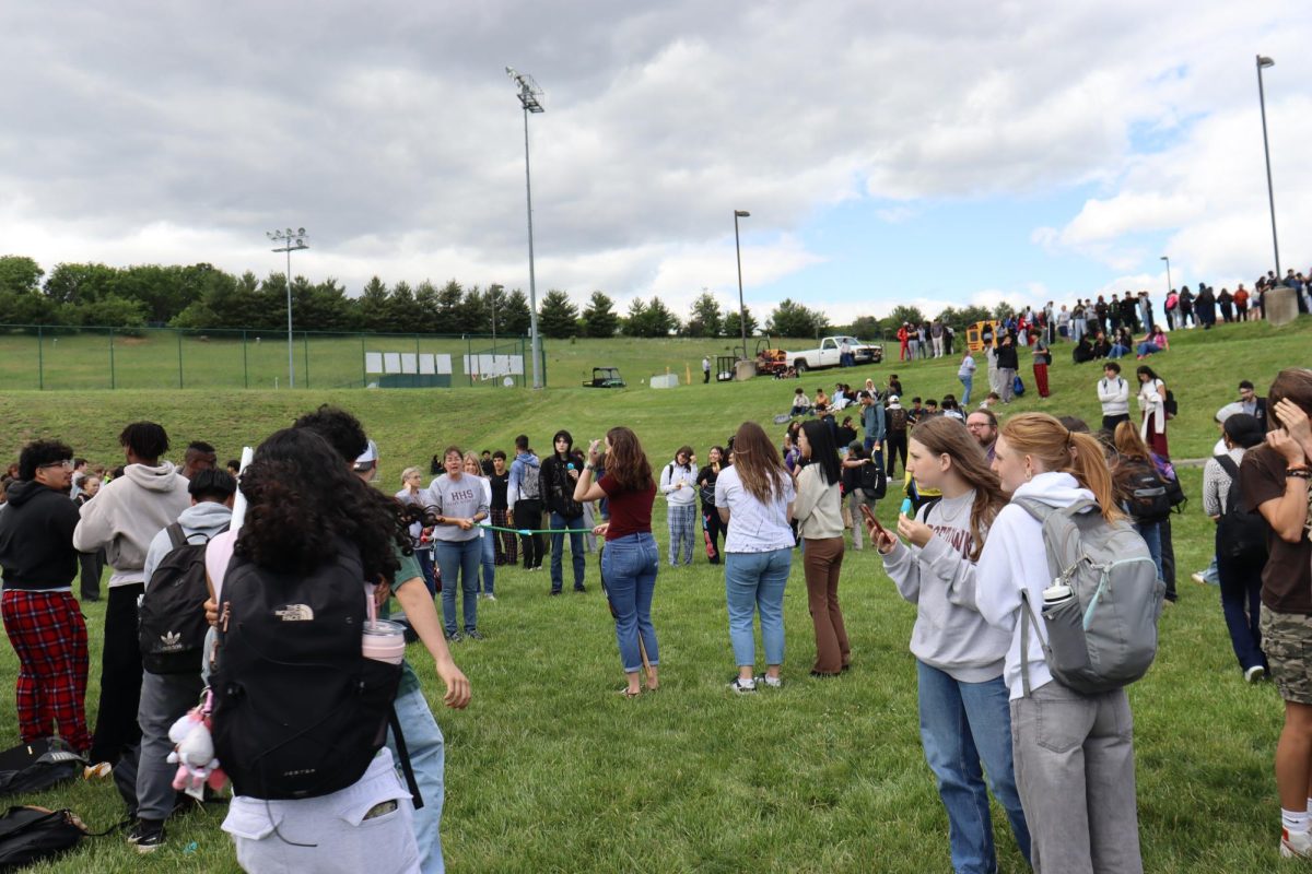 Students stand near the limbo bar.