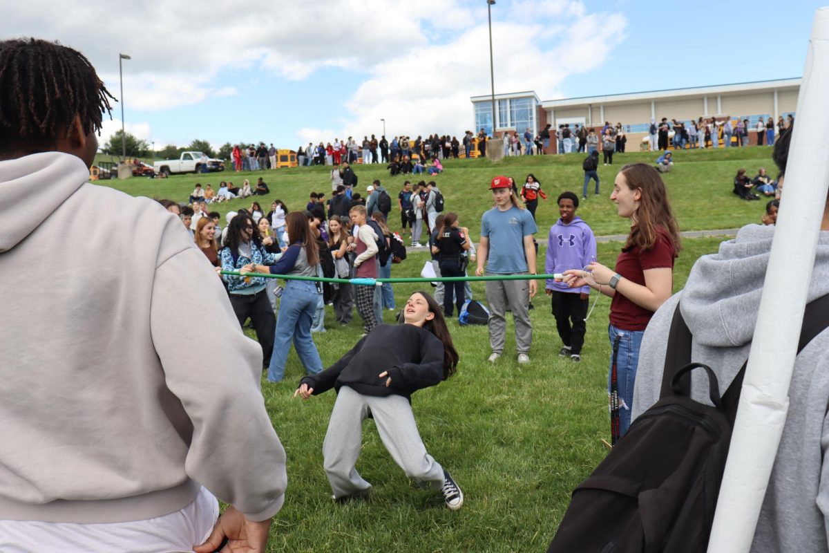 A brave student ducks  under the limbo bar.