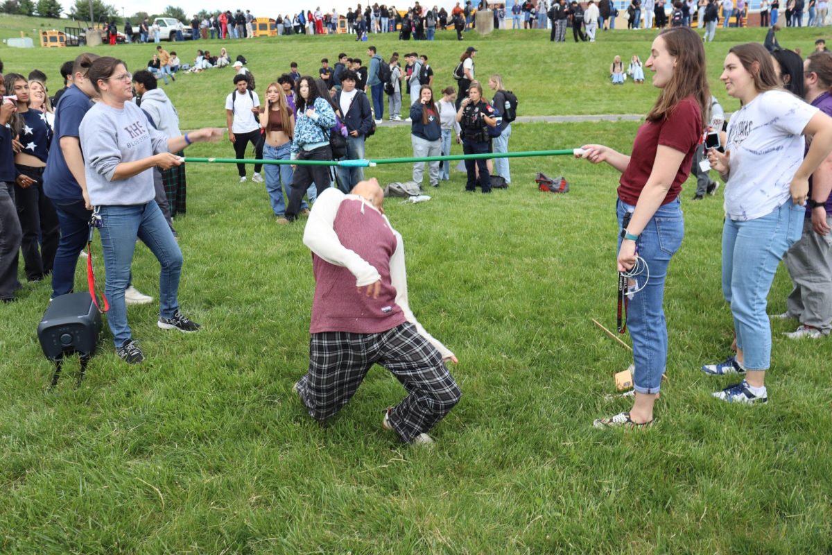 A student nearly falls over when trying to duck under the limbo bar.