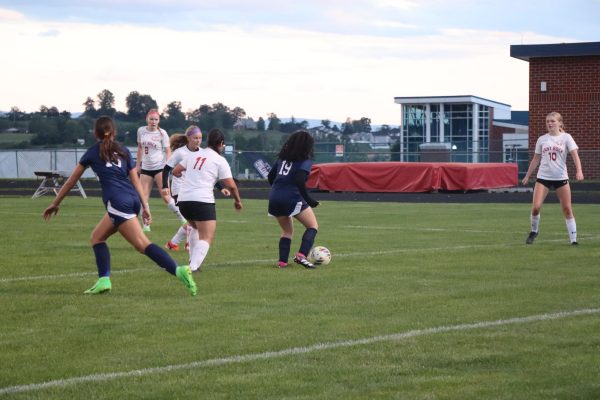 Junior Sara Hussein maintains possession of the ball despite the other team running on her. 