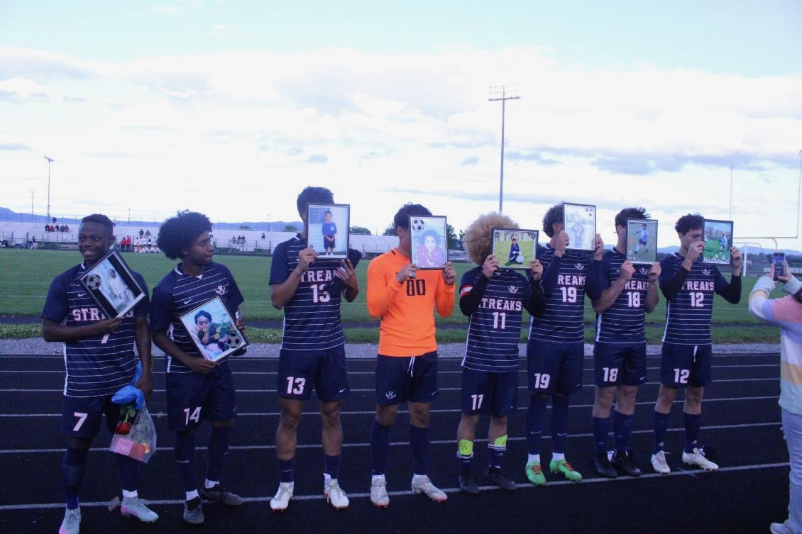 Seniors hold up baby pictures.