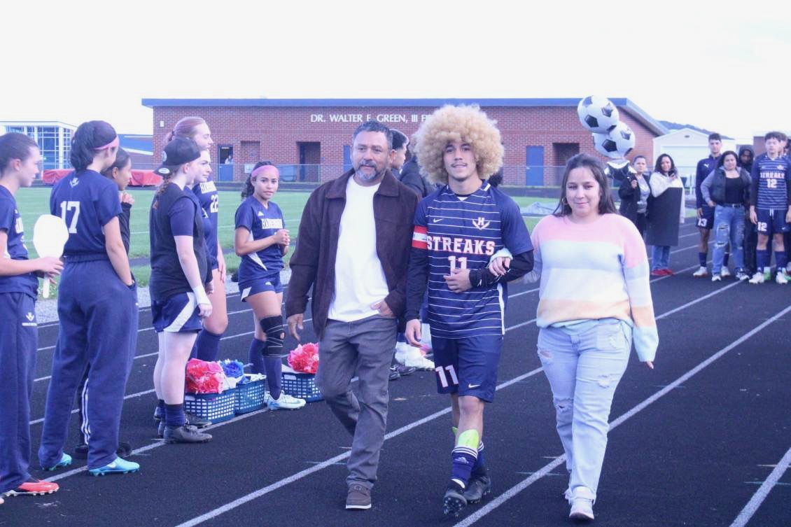 Senior Izaack Cruz walks down the track with his family.