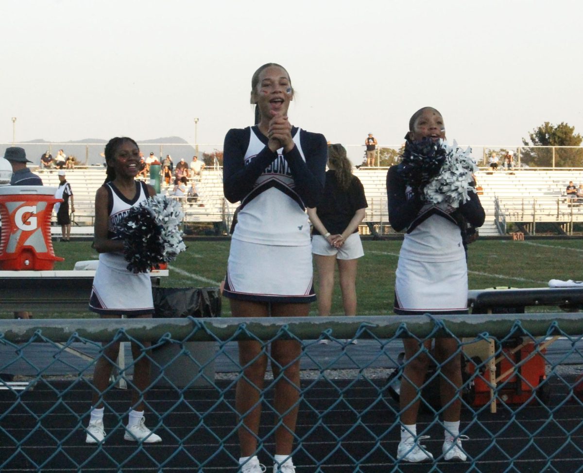 Cheerleaders are in the middle of their cheer.