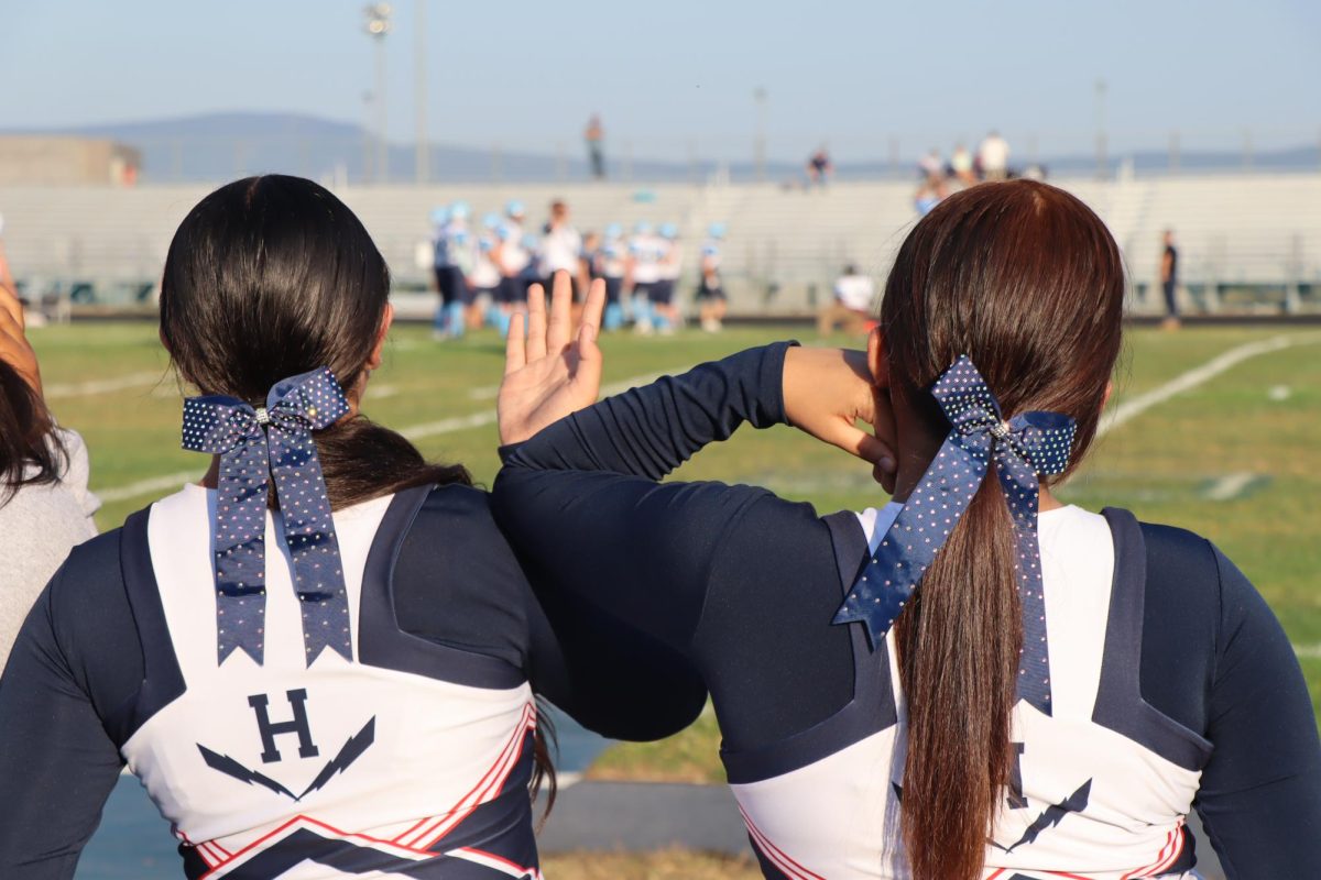 Freshmans Lili Cruz and Hetzel Vargas cheer on our football team.
