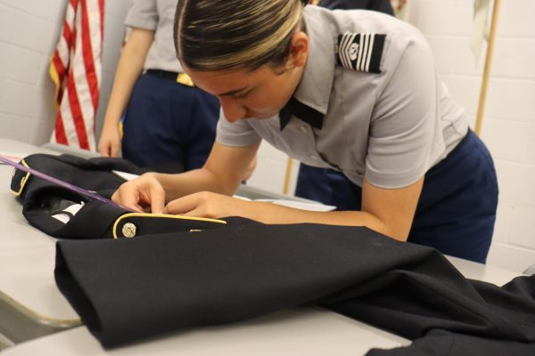 Giselle Cano Torres making sure her JROTC uniform is measured correctly for inspection.