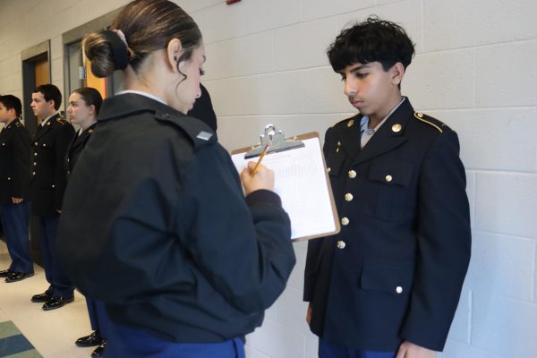 Freshman Malik Balak getting inspected by Amy Matamoras.