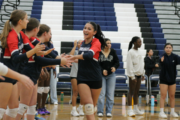 Junior Leah Yoder runs down the high-five line before the game.