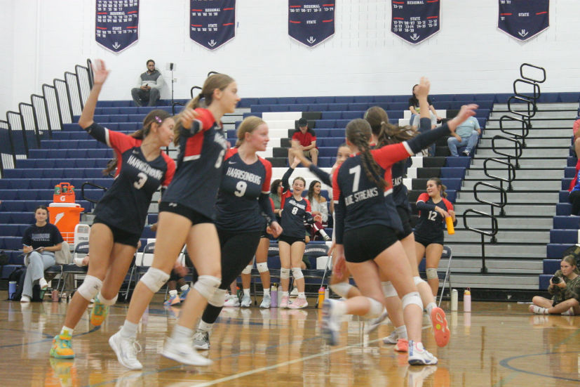 The team celebrates winning the point with a pinwheel celebration.
