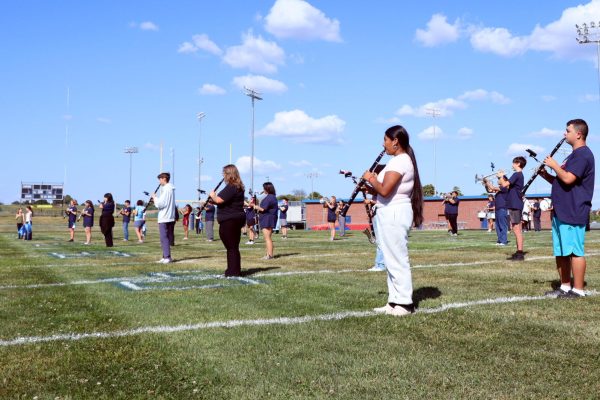 Band members play instruments on the field.
