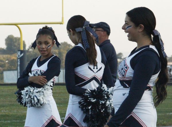 JV Cheerleaders taklk in between doing cheers.