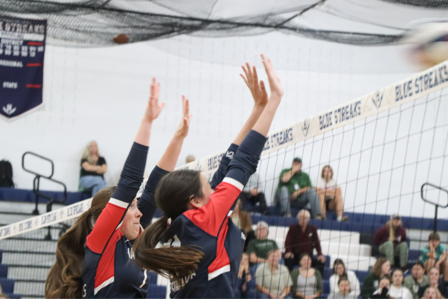 Freshman Brently Riner and sophomore Delaney Dayton jump up to block the other team's hit.