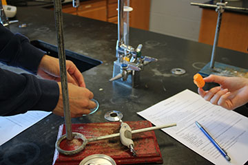 These students are doing their fire experiment and testing their hypotheses they made.