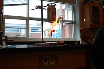 Here is a student trying out the experiment the teacher demonstrated.