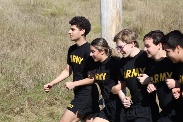 JROTC members work together to complete an obstacle course.