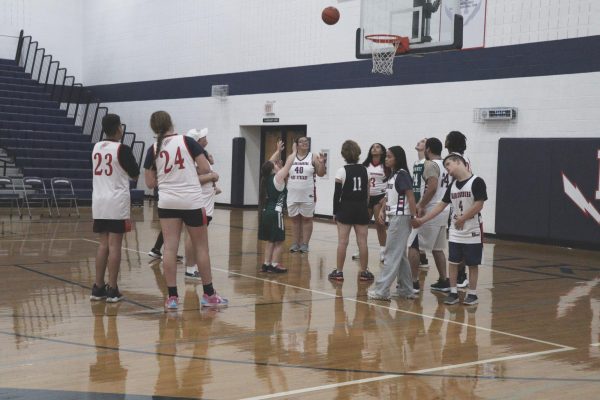 A member on the opposite team shoots a ball for the basket