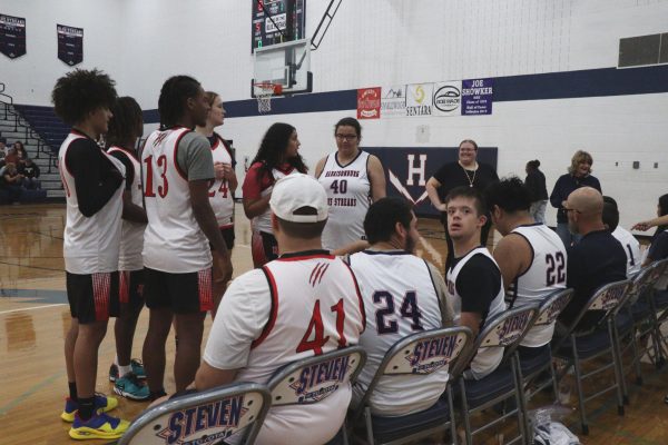 The basketball team cheering and sitting from the sideline Gloria Ottaviano, coach of the HHS Unified Basketball team, commented "What I would like others to know about leading the unified basketball team is that it is all about having fun and everyone having the opportunity to play. This is my favorite thing we do every year"