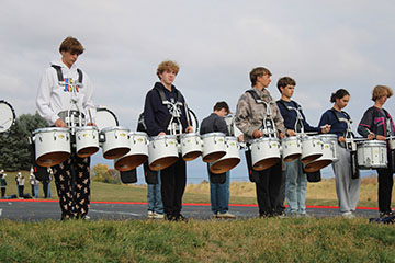 The percussions getting their beats in place before they start the practice.