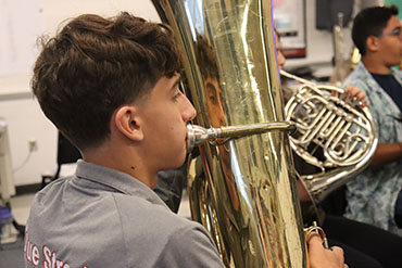Freshman Kyle Rush playing his Tuba during rehearsal.